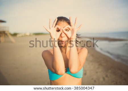 Silly young woman grimacing and having fun on the beach enjoying summer vacation holiday.Happy woman making funny face,having fun at party.Pulling funny faces.Humorous woman making someone laugh