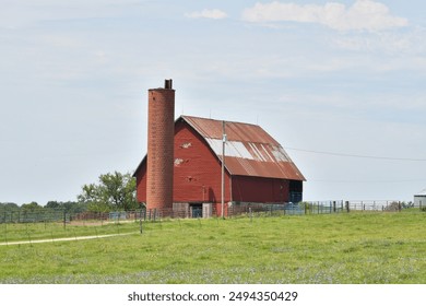 Silo by a red barn in a farm field - Powered by Shutterstock