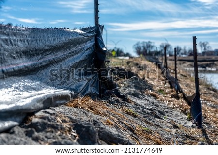  silt fence at a construction site with exposed dirt piled against the fabric