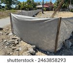 A silt fence is installed at a construction site. A Silt fence is a perimeter control device use to temporarily manage sediment at construction sites.