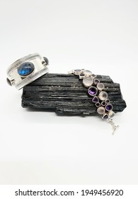 Silver Bangle And Multi Stone Bracelet Resting On A Black Tourmaline Crystal 