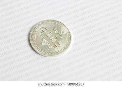 silver bitcoin on the background of binary code