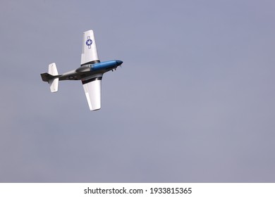 Silver And Blue Mustang Plane Fly In The Blue Sky.