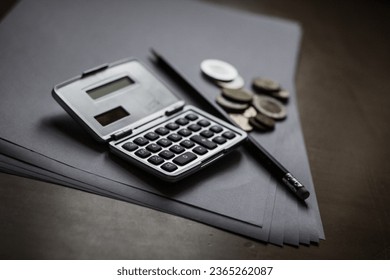 silver calculator with pencil, coins and sheet of paper as concept profit - Shutterstock ID 2365262087