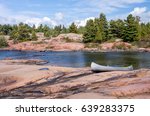 Silver Canoe On Granite Shoreline