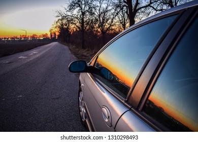 Silver Car Driving On Bumpy Road During Sunset