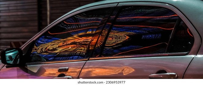 silver Car parking in the night city. reflection in glass lights of Ferris wheel. night scene. modern exterior of vehicle.  neon illuminated urban scene. long exposure shot. BATUMI, GEORGIA - Powered by Shutterstock