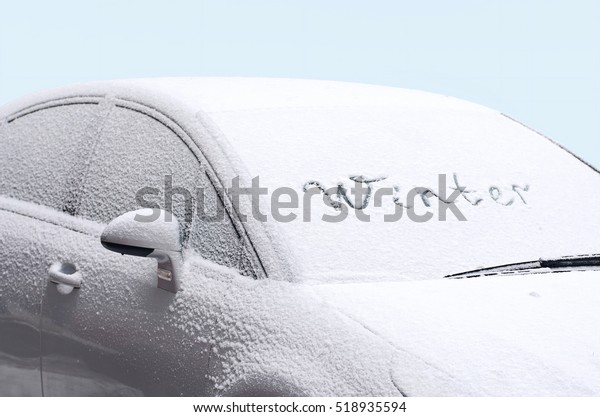 Silver car side view of frozen winter in frost on\
blue background with word \