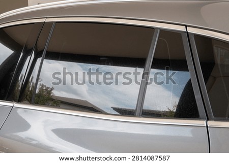Silver Car Side Windows with Clear Sky Reflection and Chrome Trim