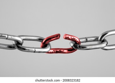 Silver chain with red broken link, concept of freedom.