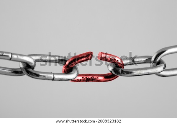 Silver\
chain with red broken link, concept of\
freedom.