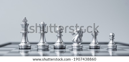 Silver Chess figure team (King, Queen, Bishop, Knight, Rook and Pawn) on Chessboard against opponent during battle. Strategy, Success, management, business planning, tactic, politic and leader concept
