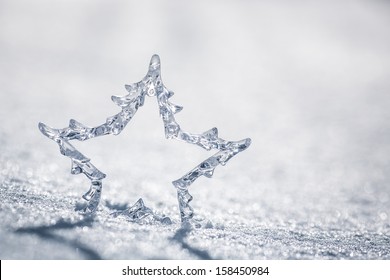 Silver Christmas Star On Real Snow Outdoors. Winter Holidays Concept. Shallow Depth Of Fields