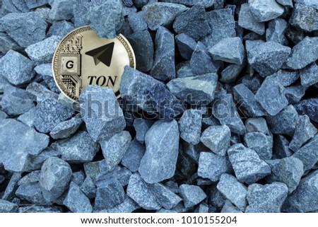 Silver coin ton in the grey gravel. Cryptocurrency TON from telegram. Search gram.