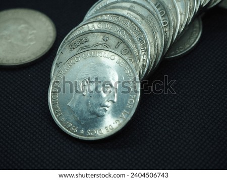Silver coins of the Caudillo Francisco Franco, 100 pesetas, on a black background