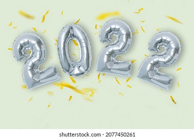 silver color Christmas 2022 balloons isolated on green background.