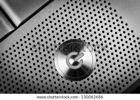 silver color  power button macro closeup  with holes grid arround