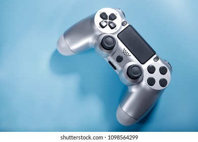 Silver console gamepad, game controller on blue background