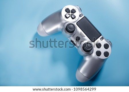 Silver console gamepad, game controller on blue background