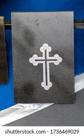 Silver Cross At Black Marble Tomb Stone