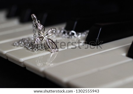 Silver cross with diamonds on the piano, jewerly