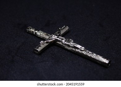 Silver cross. God protect written on it. Jesus served his life to save people and bring peace to world. Christianity is pure religion.