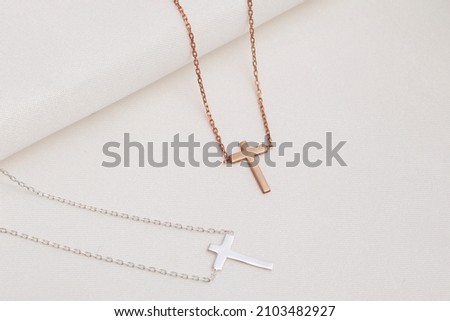 Silver cross necklace on the floor. Jewelry images that can be used in e-commerce, online sales and social media.