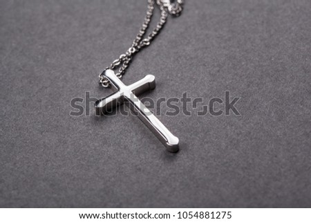 Silver cross on a gray background close up image