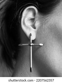 Silver Cross On A Woman's Ear