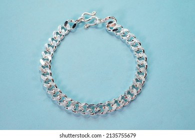 Silver Cuban Chain Link Bracelet On Blue Backbround