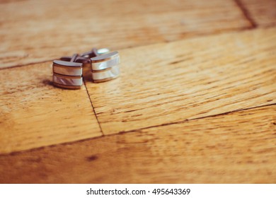 Silver Cufflinks Lie On Wooden Floor