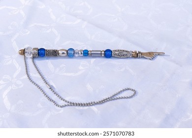 A silver, decorative, beaded yad, a pointer used to assist a Torah reader follow the Hebrew text when reading from a Torah scroll. 