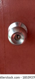 Silver Doorknob On Closed Wooden Door

