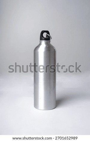 A silver drinking bottle is placed against a white background, creating a clean and modern look                               