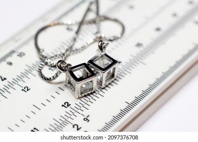 Silver earrings on a measuring device in a pawnshop
