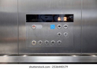 A silver elevator control panel with a blue disable sign. - Powered by Shutterstock