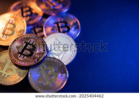 Silver Ethereum coin on dark background. Bitcoin and Ethereum coins illuminated. Crypto currency trading concept. Copyspace on right side