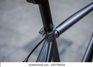 Silver fixed gear bike with black brake cable. Black seat tube and saddle