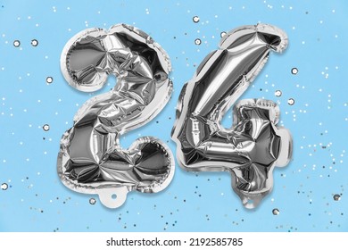 Silver Foil Balloon Number, Digit Twenty Four On A Blue Background With Sequins. Birthday Greeting Card With Inscription 24. Top View. Numerical Digit. Celebration Event, Template.