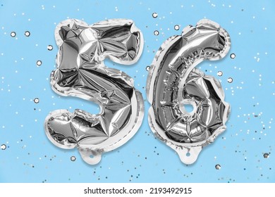 Silver Foil Balloon Number, Digit Fifty Six On A Blue Background With Sequins. Birthday Greeting Card With Inscription 56. Top View. Numerical Digit. Celebration Event, Template.