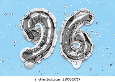 Silver Foil Balloon Number, Digit Ninety Six On A Blue Background With Sequins. Birthday Greeting Card With Inscription 96. Top View. Numerical Digit. Celebration Event, Template.