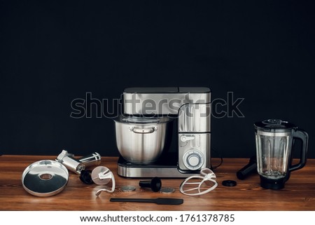 silver Food Processor standing on wooden countertop on dark background