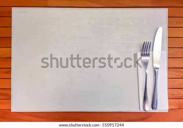 Silver Fork and knife with White Napkin Top\
View on wooden table\
background