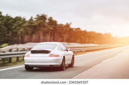 Silver German roadster coupe on the highway. Silver sport coupe. Expensive sports car rushing along the highway - Shutterstock ID 2341069107