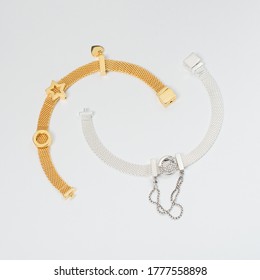 Silver And Gold Bracelets On White Background, Jewelry Flatlay On Neutral Background. Top View Of Fashion Luxury Woman Accessories, Jewelry And Shopping Concept. Trendy Flat Lay Composition.