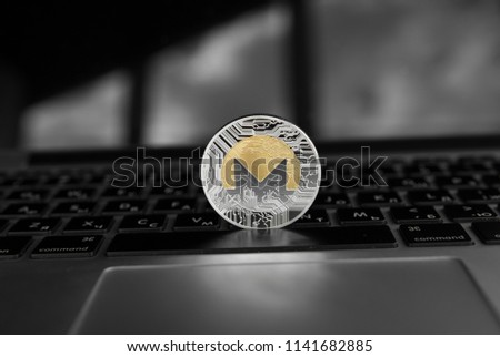 Silver gold Monero coin on a laptop keyboard. Exchange, bussiness, commercial. Profit from mining crypt currencies. Miner with ethereum coin.
