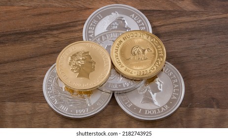 Silver and gold ounces of Australia on wooden table, silver coins, silver money, gold coins, gold money - Shutterstock ID 2182743925
