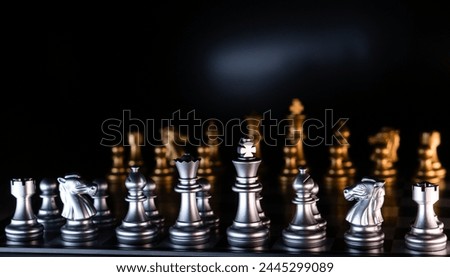 Silver and golden chess pieces on reflective board. Chessmen on a black background. Chess game