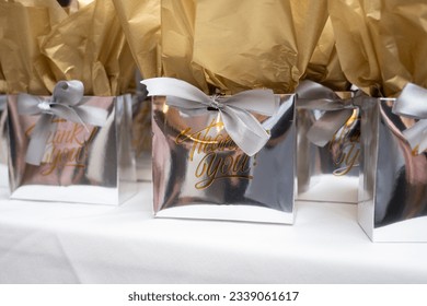 Silver goodie bags on a table with printed Thank you message - Shutterstock ID 2339061617