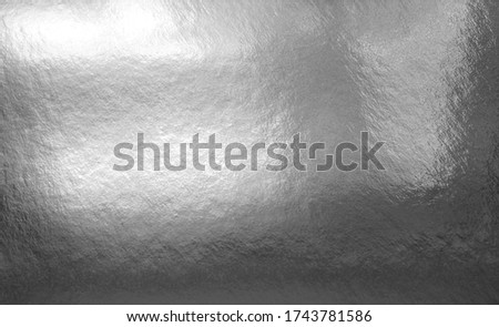 Silver gray foil texture background with shadows, highlights and glossy uneven surface
